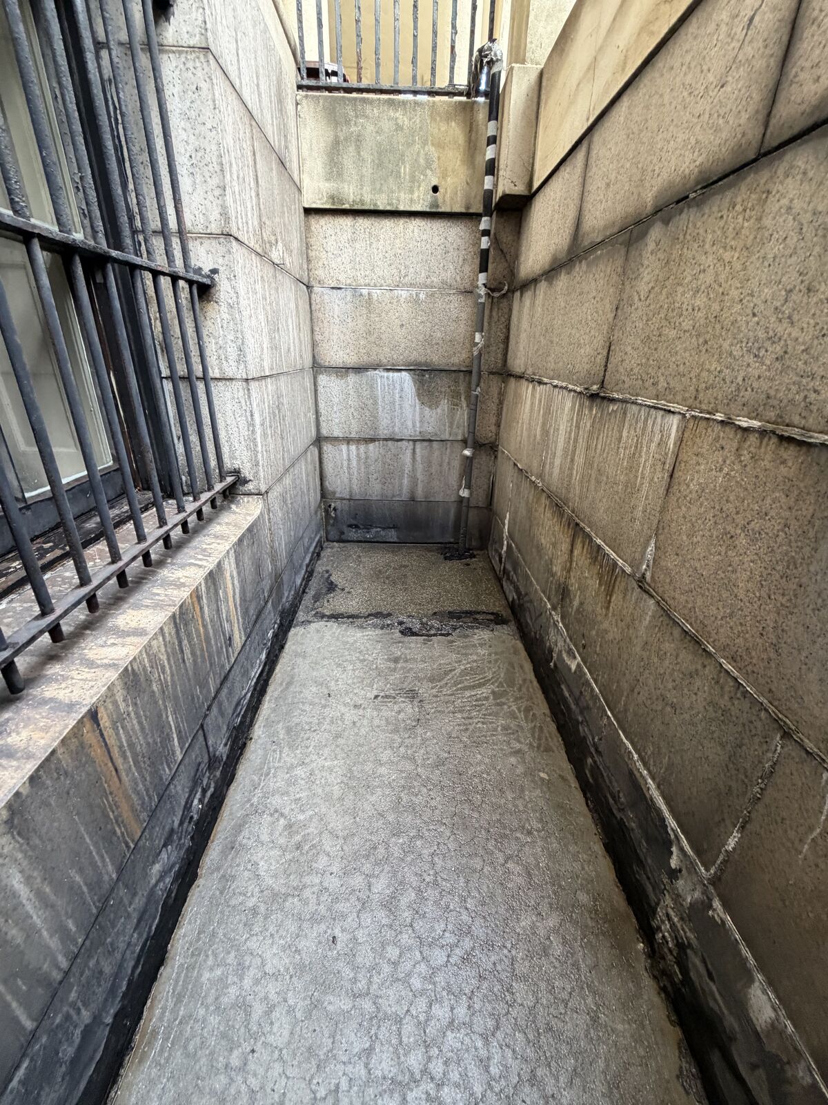 Before: staining across the areaway limestone